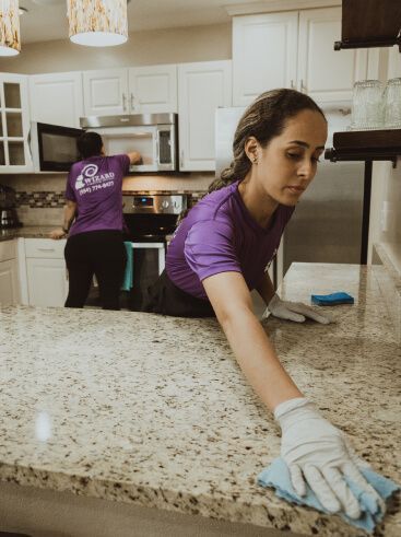 Wizard cleaner with gloves scrubbing a granite counter